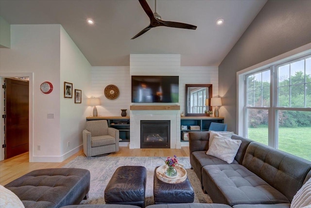 5508 Midmoor Rd, Monona, WI 53716 - living area with vaulted ceiling, ceiling fan, wood finished floors, a glass covered fireplace, and baseboards
