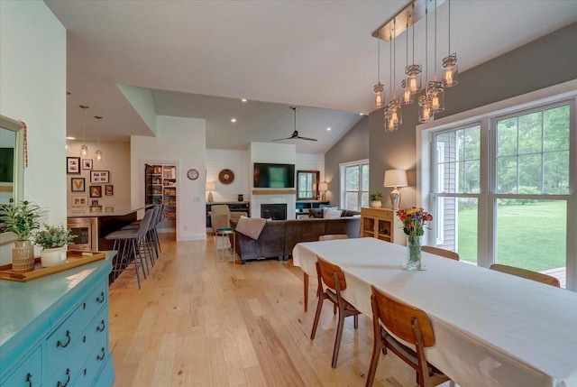 5508 Midmoor Rd, Monona, WI 53716 - dining room with light wood-style flooring, a ceiling fan, lofted ceiling, a fireplace, and recessed lighting