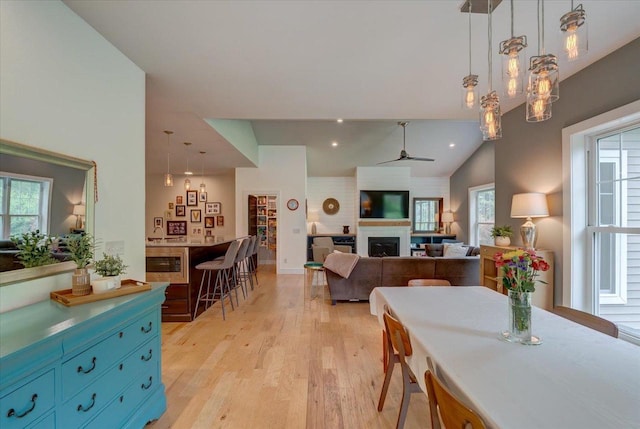 5508 Midmoor Rd, Monona, WI 53716 - dining room with plenty of natural light, light wood finished floors, a fireplace, a ceiling fan, and vaulted ceiling
