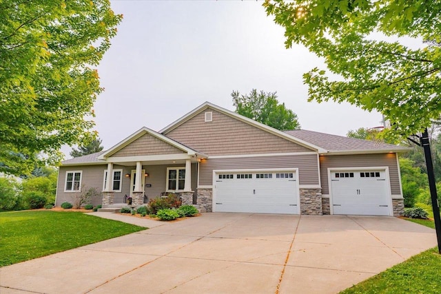5508 Midmoor Rd, Monona, WI 53716 - craftsman-style house featuring a garage, stone siding, concrete driveway, a front yard, and a porch