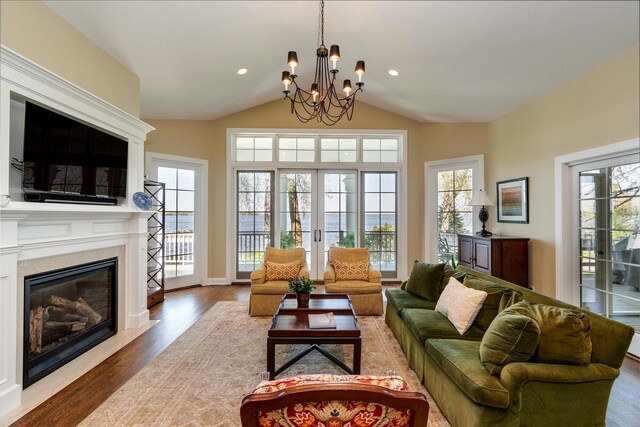 1834 Camelot Dr, Madison, WI 53705 - living area with wood finished floors, healthy amount of natural light, a chandelier, a high end fireplace, and lofted ceiling