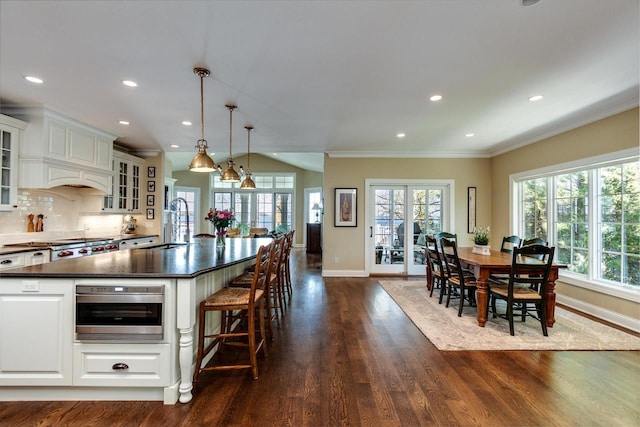 1834 Camelot Dr, Madison, WI 53705 - kitchen featuring dark countertops, baseboards, dark wood-style floors, white cabinets, and ornamental molding