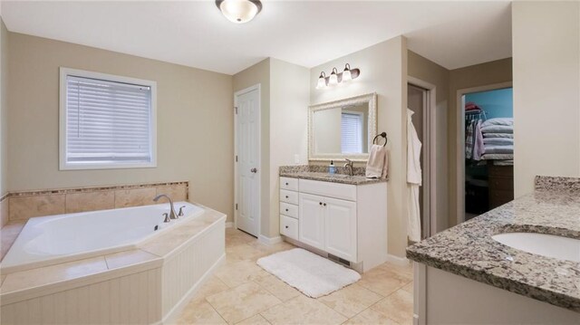 1604 Lake Rd, Altoona, WI 54720 - full bathroom featuring two vanities, a bath, a spacious closet, and tile patterned flooring