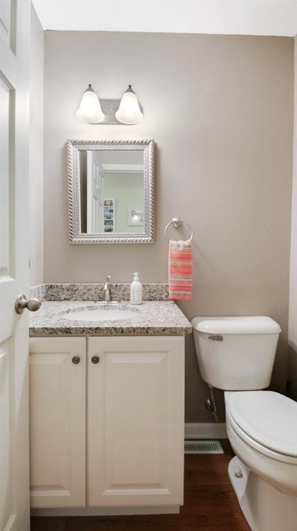 1604 Lake Rd, Altoona, WI 54720 - half bathroom featuring toilet, vanity, wood finished floors, and baseboards