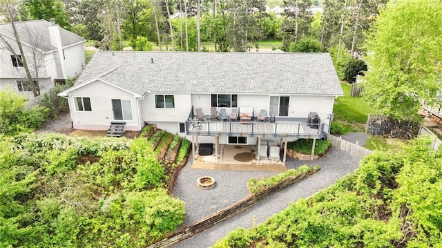 1604 Lake Rd, Altoona, WI 54720 - rear view of property with a deck, a patio area, roof with shingles, an outdoor fire pit, and view of wooded area