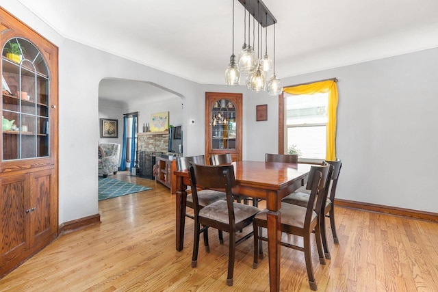 813 W Summer St, Appleton, WI 54914 - dining area with arched walkways, light wood-style flooring, and baseboards