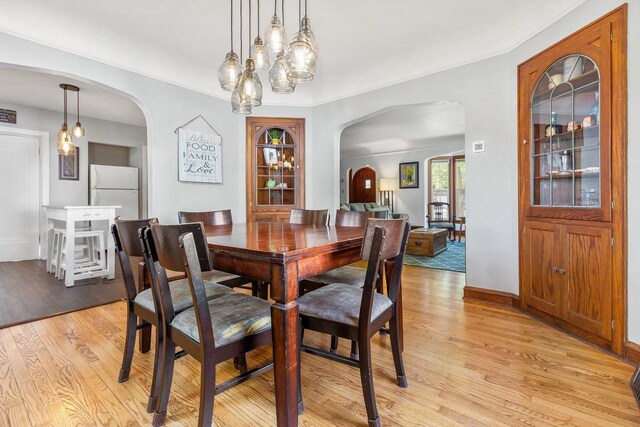 813 W Summer St, Appleton, WI 54914 - dining room featuring arched walkways, light wood-style floors, and baseboards
