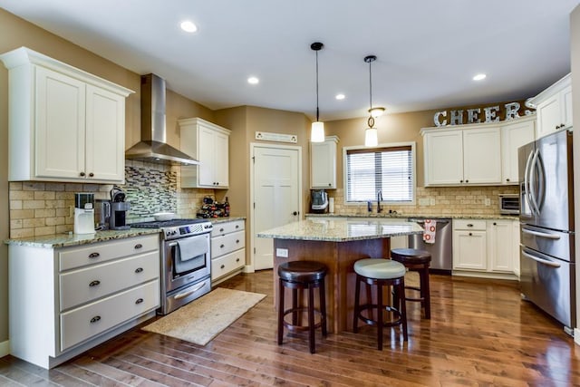 6679 S Chickahauk Trl, Middleton, WI 53562 - kitchen with appliances with stainless steel finishes, wall chimney range hood, a center island, dark wood-type flooring, and a kitchen bar
