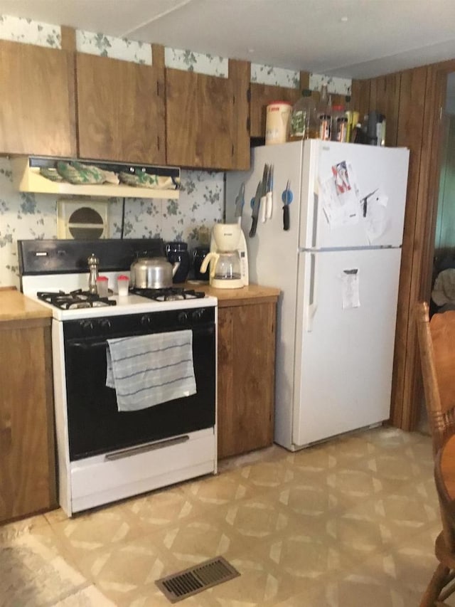 N7777 Kitty Dell Rd, Crivitz, WI 54114 - kitchen with white appliances, light flooring, brown cabinets, range hood, and light countertops