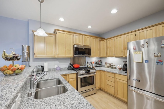 3710 N Oakland Ave Unit 304, Shorewood, WI 53211 - kitchen featuring appliances with stainless steel finishes, a sink, light brown cabinetry, light wood-style floors, and light stone countertops