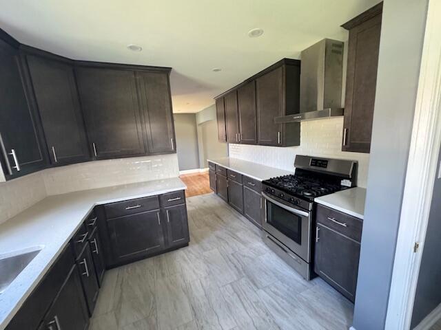 2254 W Roosevelt Dr, Milwaukee, WI 53209 - kitchen featuring stainless steel range with gas cooktop, wall chimney exhaust hood, backsplash, light countertops, and dark brown cabinetry