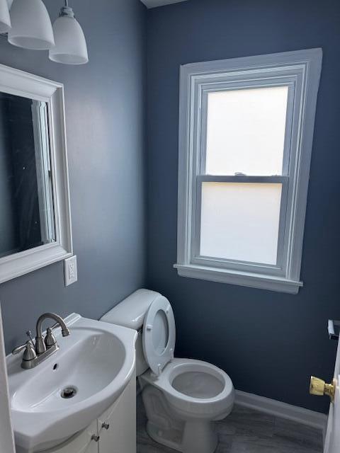 2254 W Roosevelt Dr, Milwaukee, WI 53209 - half bathroom featuring healthy amount of natural light, toilet, vanity, and baseboards