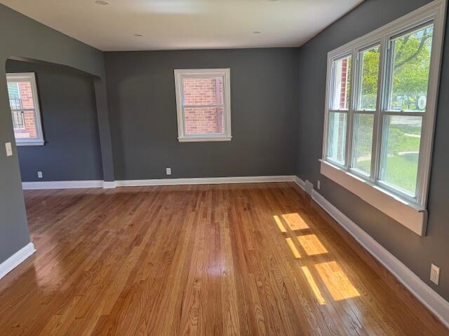 2254 W Roosevelt Dr, Milwaukee, WI 53209 - spare room featuring wood finished floors, baseboards, and arched walkways