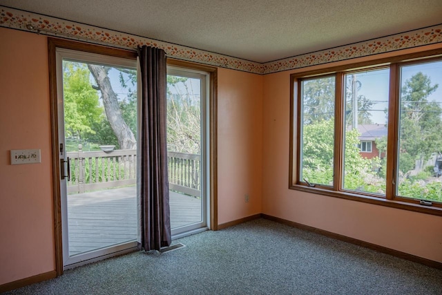 706 Tremont St, Mauston, WI 53948 - empty room with carpet flooring, a textured ceiling, and baseboards