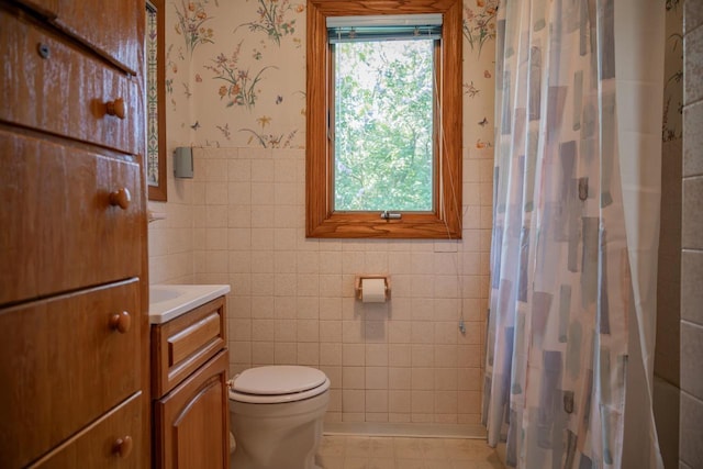 706 Tremont St, Mauston, WI 53948 - full bath featuring wallpapered walls, vanity, toilet, tile walls, and a shower with shower curtain