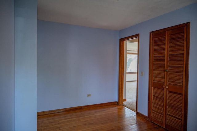 706 Tremont St, Mauston, WI 53948 - unfurnished bedroom with a closet, baseboards, and wood-type flooring