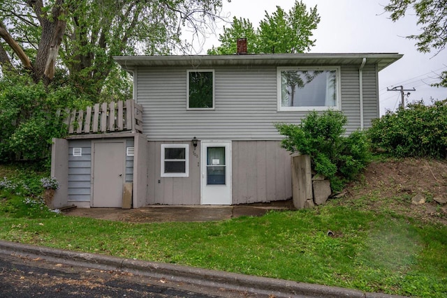 706 Tremont St, Mauston, WI 53948 - back of house with a chimney and a yard