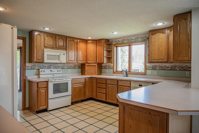 706 Tremont St, Mauston, WI 53948 - kitchen featuring white appliances, a sink, a peninsula, a textured ceiling, and light countertops