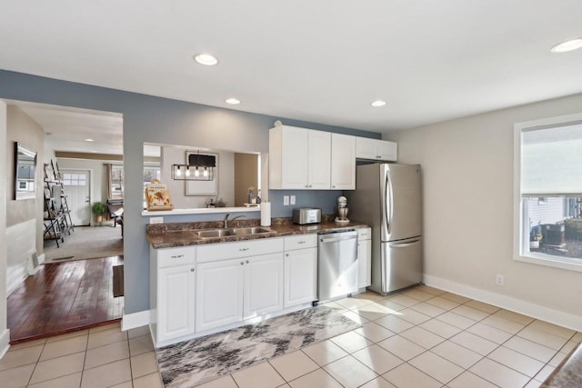 707 E Roland St, Oconomowoc, WI 53066 - kitchen featuring appliances with stainless steel finishes, a sink, dark countertops, white cabinets, and recessed lighting