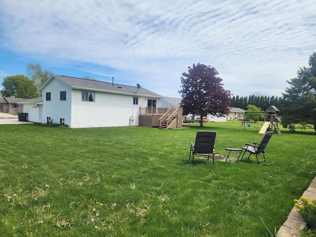 326 N 15th St, Oostburg, WI 53070 - view of green lawn with a wooden deck, a playground, stairs, and a garage