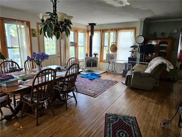 N10449 State Road 25, Wheeler, WI 54772 - dining room featuring a wood stove, hardwood / wood-style flooring, and ornamental molding