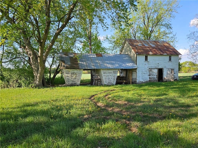N10449 State Road 25, Wheeler, WI 54772 - rear view of house featuring a lawn, an outdoor structure, and metal roof
