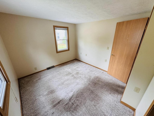1344 Mckinley Ave, Beloit, WI 53511 - spare room with light carpet, a textured ceiling, and baseboards