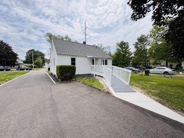 1344 Mckinley Ave, Beloit, WI 53511 - view of front facade with roof with shingles, a front lawn, and a chimney