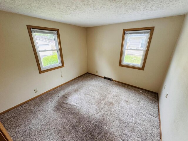 1344 Mckinley Ave, Beloit, WI 53511 - empty room with carpet flooring, a textured ceiling, and baseboards