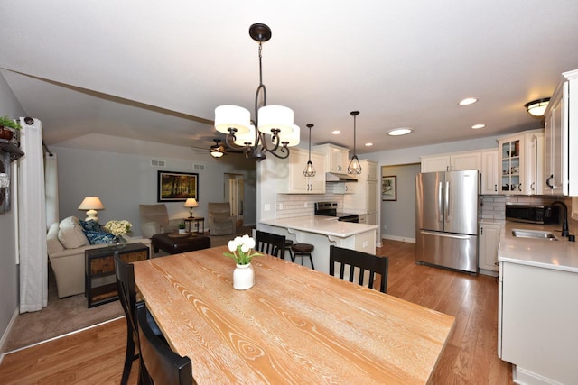 504 Sand Dr, West Bend, WI 53095 - dining area with a chandelier, wood finished floors, baseboards, and recessed lighting