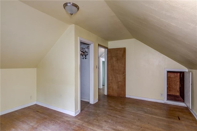 2561 86th St, Eau Claire, WI 54703 - additional living space with vaulted ceiling, wood finished floors, and baseboards