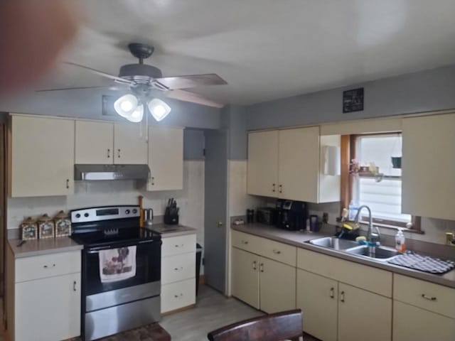 4507 S Griffin Ave, Milwaukee, WI 53207 - kitchen with stainless steel range with electric stovetop, under cabinet range hood, a sink, a ceiling fan, and cream cabinetry
