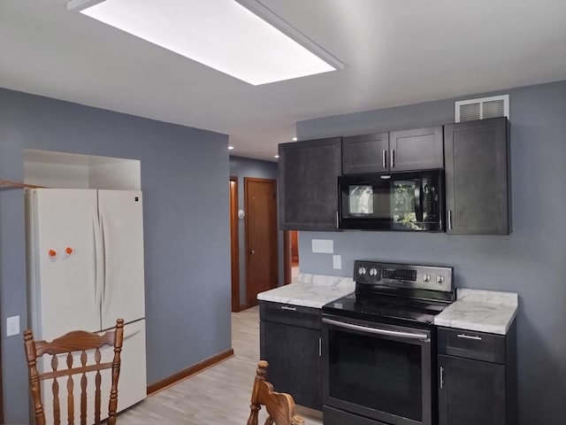 4507 S Griffin Ave, Milwaukee, WI 53207 - kitchen featuring freestanding refrigerator, black microwave, stainless steel range with electric cooktop, light countertops, and light wood-type flooring