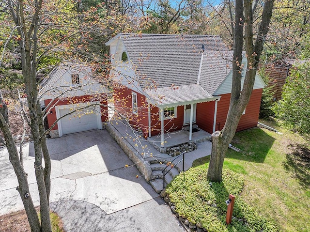 5515 Evergreen Dr, Sheboygan, WI 53081 - view of front facade featuring a porch, concrete driveway, roof with shingles, an attached garage, and a front yard