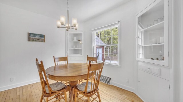 5515 Evergreen Dr, Sheboygan, WI 53081 - dining area featuring a chandelier, light wood-style flooring, and baseboards