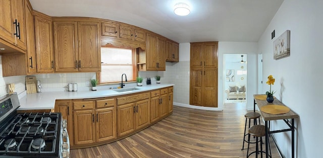 901 S 90th St, West Allis, WI 53214 - kitchen with stainless steel range with gas stovetop, a sink, brown cabinets, and dark wood-style flooring