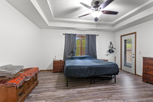 2150 E Carly Ct, Milton, WI 53563 - bedroom featuring a raised ceiling, wood finished floors, access to outside, and baseboards