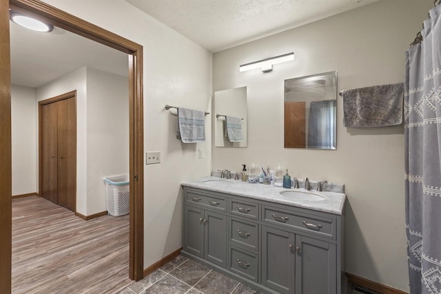 2150 E Carly Ct, Milton, WI 53563 - full bathroom with double vanity, baseboards, and wood finished floors