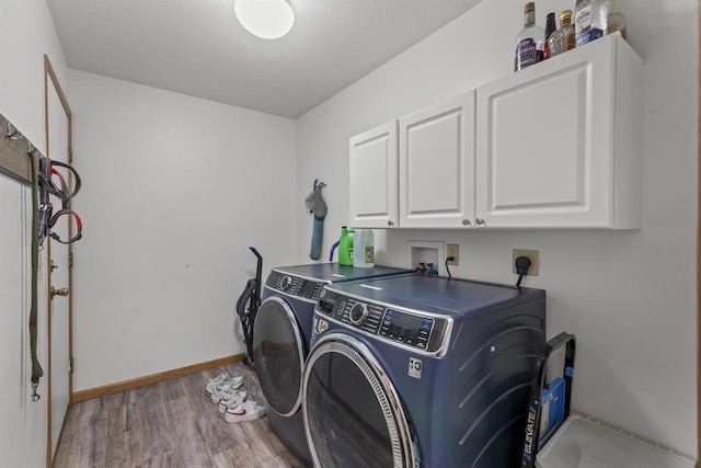 2150 E Carly Ct, Milton, WI 53563 - washroom featuring cabinet space, light wood-style floors, washing machine and clothes dryer, and baseboards
