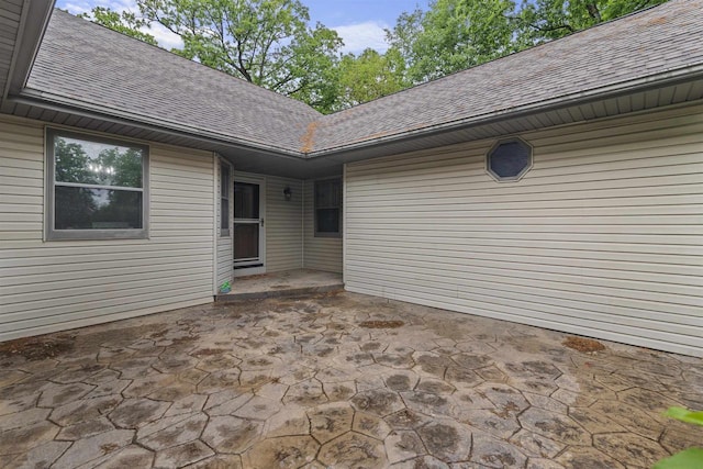 2150 E Carly Ct, Milton, WI 53563 - view of exterior entry with a shingled roof and a patio area