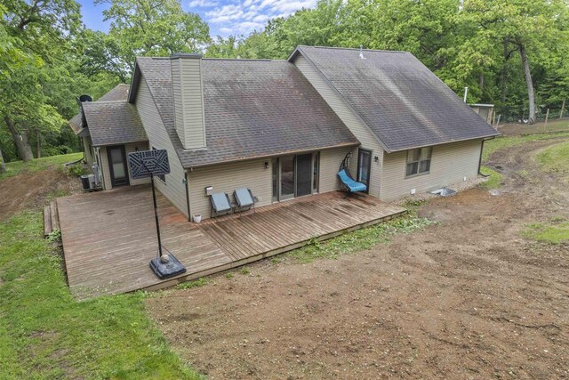 2150 E Carly Ct, Milton, WI 53563 - back of property with a wooden deck, roof with shingles, a chimney, and view of wooded area