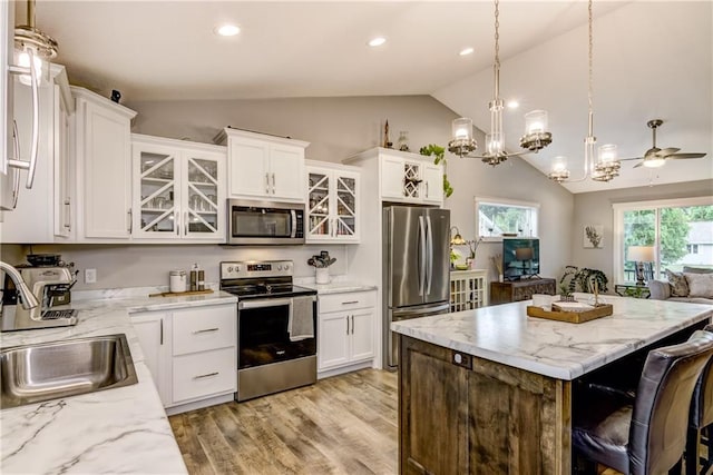 4567 Springfield Dr, Eau Claire, WI 54701 - kitchen with appliances with stainless steel finishes, lofted ceiling, a sink, a kitchen island, and glass insert cabinets