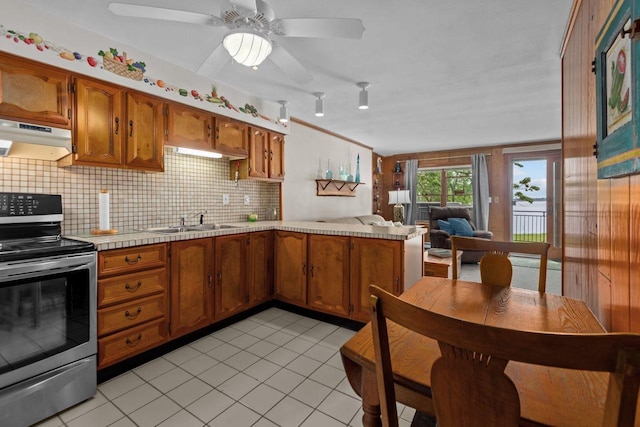 N3510 Lotus Dr, Montello, WI 53949 - kitchen with stainless steel range with electric cooktop, under cabinet range hood, a sink, light tile patterned floors, and decorative backsplash