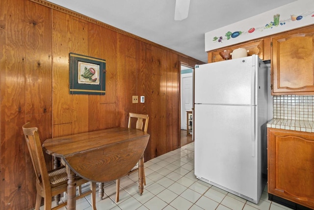 N3510 Lotus Dr, Montello, WI 53949 - dining room with wood walls, a ceiling fan, and light tile patterned floors