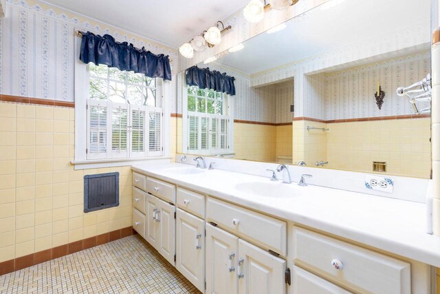 326 W Parkway Blvd, Appleton, WI 54911 - bathroom featuring wallpapered walls, tile walls, double vanity, a wainscoted wall, and tile patterned flooring