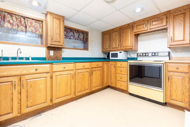 326 W Parkway Blvd, Appleton, WI 54911 - kitchen with white appliances, a sink, a paneled ceiling, finished concrete flooring, and brown cabinets