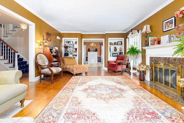 326 W Parkway Blvd, Appleton, WI 54911 - living room featuring stairs, wood finished floors, crown molding, a premium fireplace, and built in shelves