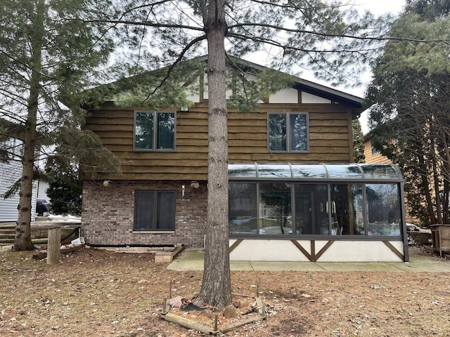 1159 Elmhurst Ln, Oshkosh, WI 54904 - back of house with a sunroom and brick siding