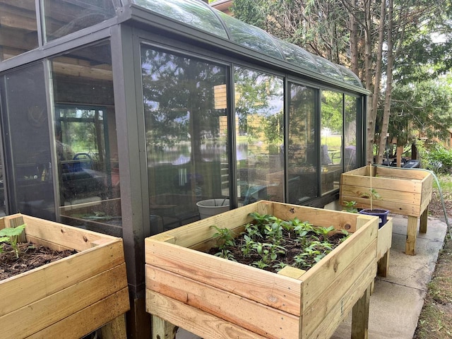 1159 Elmhurst Ln, Oshkosh, WI 54904 - wooden deck with a sunroom, a vegetable garden, and a water view
