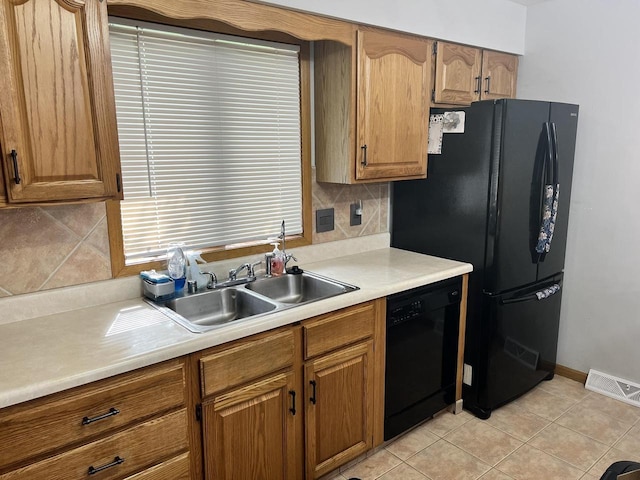 1159 Elmhurst Ln, Oshkosh, WI 54904 - kitchen with black appliances, a sink, light countertops, decorative backsplash, and light tile patterned floors